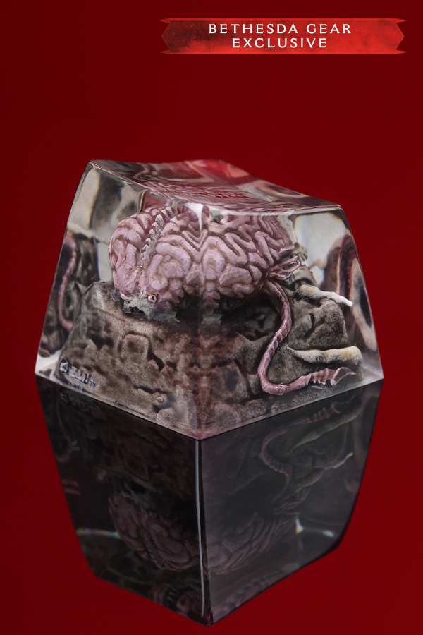 Glossy, hexagonal object with brain design on a red background, labeled 'Bethesda Gear Exclusive'.