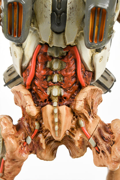 Close-up shot of the DOOM Eternal Revenant Statue, showing the details of the demon’s lower back and pelvis. The vertebrae and the red flesh of the back are exposed. Red wires from the cybernetics run along the back and connect the pelvis to the thighs.