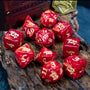The set’s 11 polyhedral dice, showing the details of their pearlescent red resin, gold-colored numbers, and the dragon head symbol in the place of each die’s highest digit.