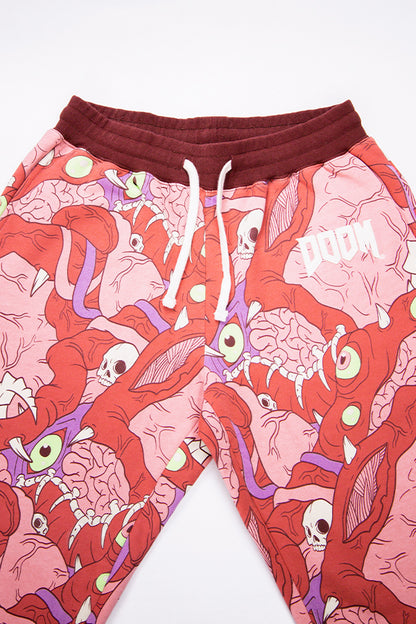 Detail shot of the upper part of the DOOM Meat Sweats, showing the details of the artwork, the ribbed burgundy waistband with flat dawcords and the DOOM logo appliqué on the left hip.